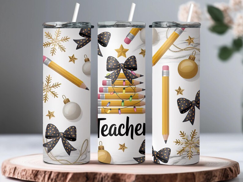 Puede incluir: Tres vasos aislados blancos con detalles en negro y dorado. Los vasos presentan l&aacute;pices, lazos, copos de nieve y la palabra "Teacher". Cada vaso tiene una pajita blanca y una tapa negra.