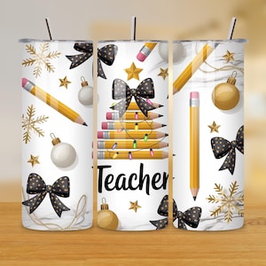 Puede incluir: Un vaso blanco con un dise&ntilde;o festivo que presenta l&aacute;pices, lazos, copos de nieve y adornos. La palabra "Teacher" se muestra en escritura negra. El dise&ntilde;o incluye detalles dorados y negros, y una pajita.