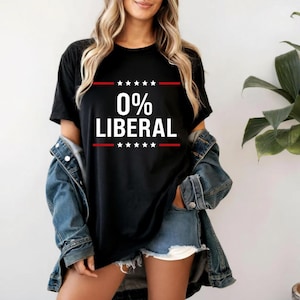 May include: Black t-shirt with the text "0% LIBERAL" in white, with red lines above and below the text, and stars. The shirt is worn with a denim jacket and shorts.