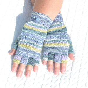 Hand knitted green striped convertible half finger gloves with mitten flaps on model's hands