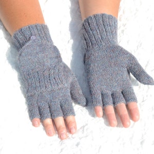 Puede incluir: Un par de guantes sin dedos grises con un detalle de botón en un guante.