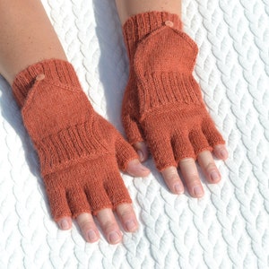 Hand knitted terracotta / copper alpaca convertible gloves with mitten flap on model's hands