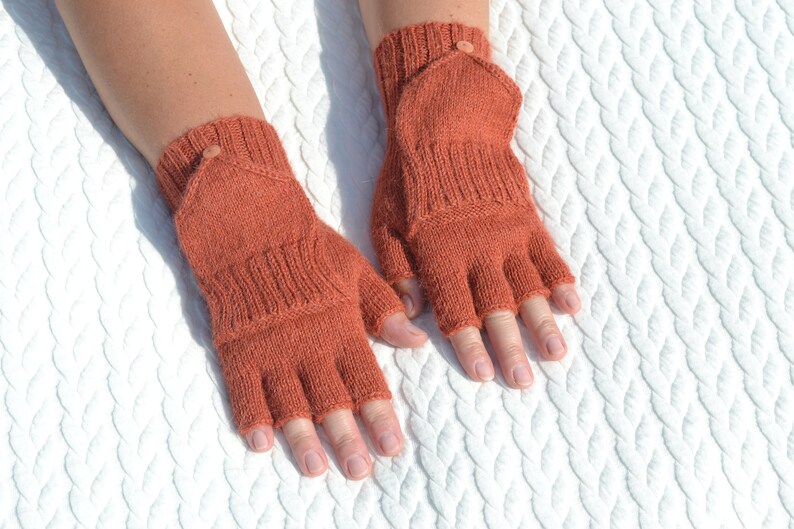 Hand knitted terracotta / copper alpaca convertible gloves with mitten flap on model's hands