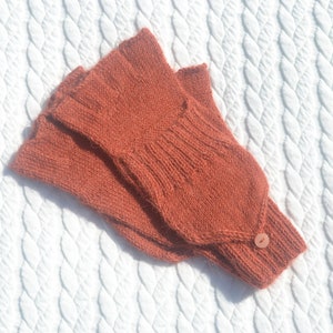 Hand knitted terracotta / copper alpaca convertible gloves with mitten flap on model's hands