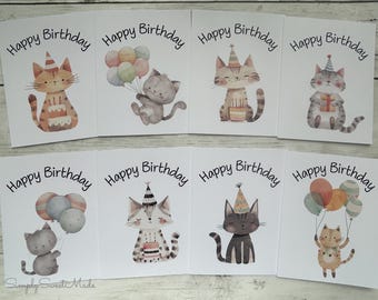 May include: A collection of eight birthday cards with watercolor illustrations of cats. Each card features a different cat design, some holding balloons or a cake, with the words "Happy Birthday" in black script.