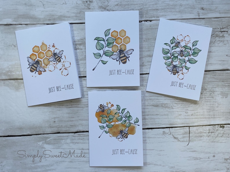 May include: Four greeting cards with a watercolor illustration of bees and honeycomb. Each card has the text "JUST BEE-CAUSE" printed on it.