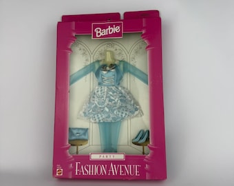 May include: A Barbie Fashion Avenue Party clothing set in a pink box. The set includes a light blue long-sleeve dress with a white lace overlay, a matching light blue clutch, and light blue high-heeled shoes. The packaging features the Barbie logo.