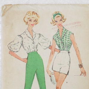May include: A vintage McCall's 5424 sewing pattern envelope featuring illustrations of two outfits. One shows a white blouse with puff sleeves and green trousers. The other shows a green patterned sleeveless collared shirt and white shorts.