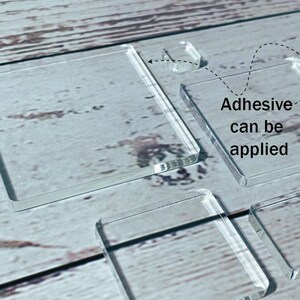Puede incluir: Cuadrados y rectángulos de acrílico transparente de varios tamaños se muestran sobre una superficie clara con vetas de madera. El texto "Adhesive can be applied" es visible. Estas piezas son probablemente para proyectos de manualidades o bricolaje.