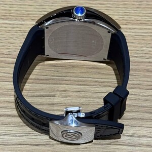 May include: A luxury wristwatch with a black leather band and a silver-tone clasp. The watch face is rectangular with a silver bezel and a blue gem on top. The band is approximately 20 cm long.