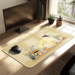 May include: A rectangular mouse pad with a light yellow background. The pad features an illustration of a hamster reading a book under a desk lamp, surrounded by stacks of books and potted plants. A black computer mouse is on the left.