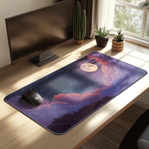 May include: A rectangular mouse pad featuring a night sky design with a full moon, stars, and purple and pink clouds. A black computer mouse is on the left side of the pad. The pad is on a wooden desk.
