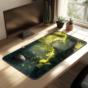 May include: A rectangular mouse mat depicting a tranquil forest scene with a sleeping cat. The design uses green and yellow hues, with a black mouse on the left. The mat is on a wooden desk, with a computer monitor in the background.