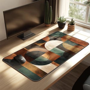 May include: A rectangular mouse pad with a geometric design in shades of brown, green, and beige. The pattern features overlapping circles and rectangles. A black computer mouse is on the left side of the pad.