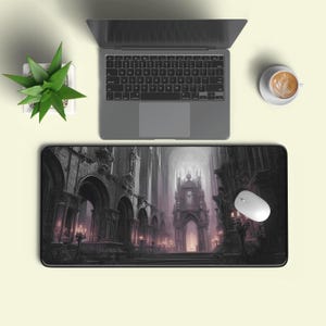 May include: A black rectangular mouse mat with a gothic cathedral design featuring arches, spires, and a central throne-like structure. A laptop, mouse, and a cup of coffee are also visible.