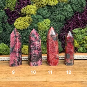 Puede incluir: Cuatro cristales rectangulares pulidos con puntas. Los cristales son principalmente rojos con vetas negras. Los n&uacute;meros 9, 10, 11 y 12 est&aacute;n impresos en la base de cada cristal. El fondo presenta musgo verde, amarillo y morado.