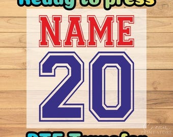 May include: A DTF transfer featuring the text Ready to press at the top and DTF Transfer at the bottom in a multi-colored font. The center displays the word NAME in red block letters above the large blue number 20 in a varsity style font.