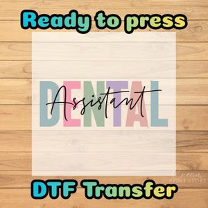 May include: A DTF transfer with the words "Ready to press" in a teal and black font. The word "Dental" is in pastel colors, and the word "Assistant" is in a black script font. The words "DTF Transfer" are in a teal and yellow font.
