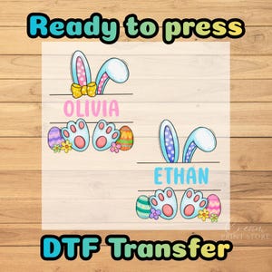 May include: A DTF transfer design featuring bunny ears, paw prints, and Easter eggs. The design includes the names "Olivia" and "Ethan". The text "Ready to press" and "DTF Transfer" are also included.