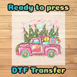 May include: A pink vintage truck illustration with a Christmas theme. The truck bed is filled with wrapped gifts and a candy cane. The image includes text that says "Ready to press" and "DTF Transfer".