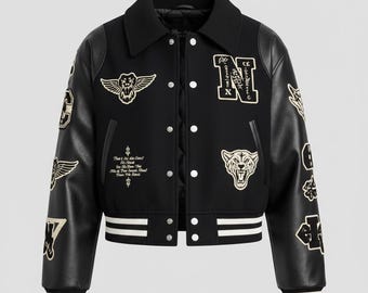 May include: Black varsity jacket with white and gold embroidered patches. It has a black collar, black leather sleeves, and white striped cuffs and hem. The jacket features a button-up front and various embroidered designs, including wings, a lion, and text.