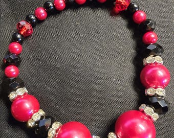 Pulseira statement vermelha e preta com miçangas, joia ousada feita à mão com detalhes em cristal.