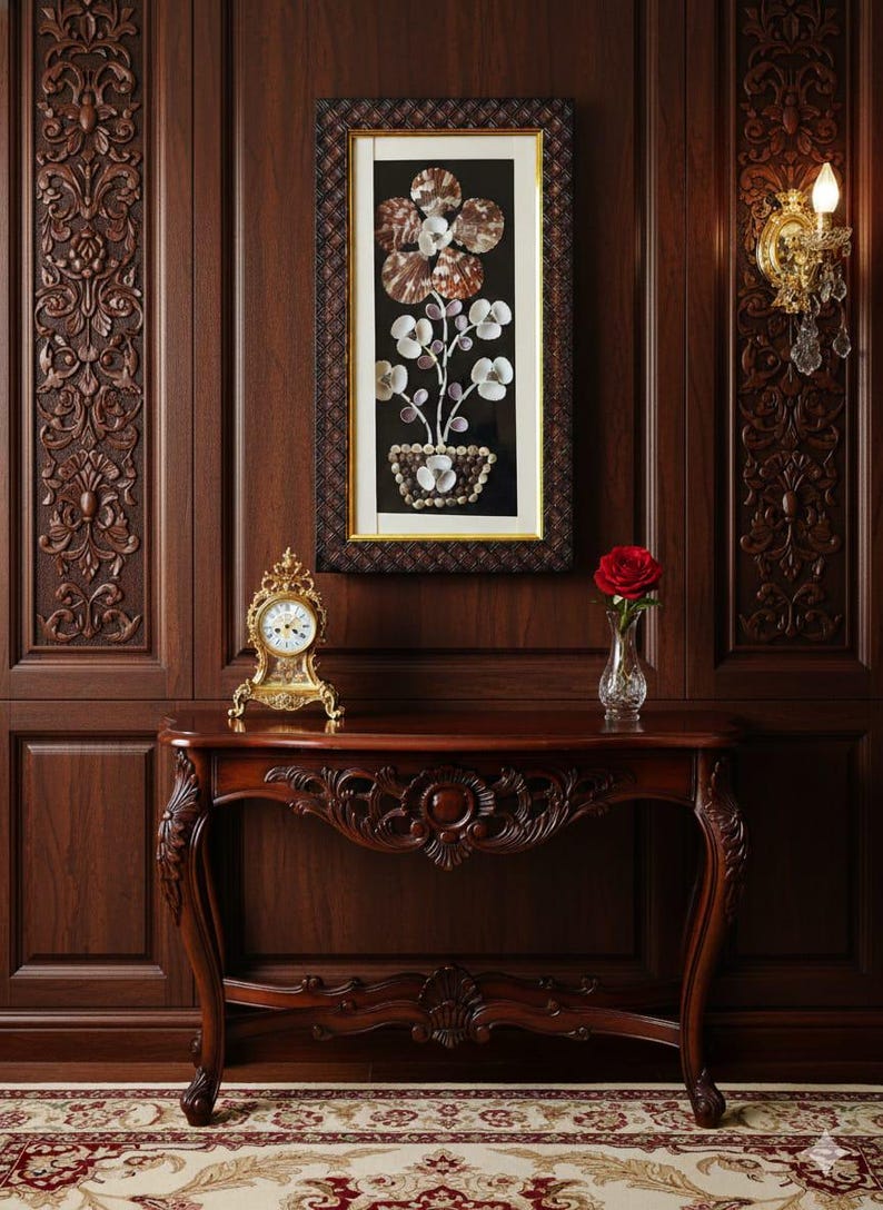 K&ouml;nnte beinhalten: Eine Konsole aus dunklem Holz mit kunstvollen Schnitzereien, ein gerahmtes Muschelbild und eine goldene Uhr. Eine rote Rose in einer Glasvase steht auf dem Tisch. Die Wand ist mit dunklem Holz verkleidet und hat eine dekorative Wandleuchte.