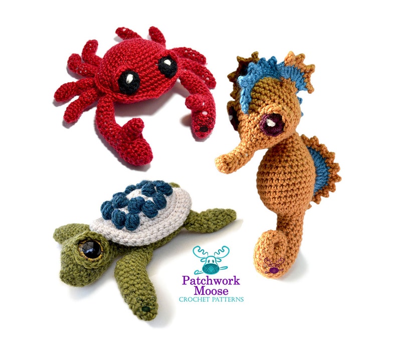K&ouml;nnte beinhalten: Geh&auml;kelte Meeresbewohner: eine rote Krabbe, ein Seepferdchen mit blauen und orangen Akzenten und eine gr&uuml;ne Schildkr&ouml;te mit blau-wei&szlig;em Panzer. Das Logo von Patchwork Moose Crochet Patterns ist zu sehen.