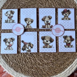 Puede incluir: Un conjunto de ocho tarjetas y dos pegatinas circulares con adorables cachorros de dibujos animados. Cada tarjeta presenta una ilustración diferente de un cachorro y una serie de círculos en blanco. Las pegatinas tienen el texto "Funny & Money" y "by Annette".