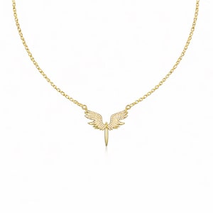 May include: A gold-colored necklace featuring a pendant shaped like angel wings. The wings are embellished with small, sparkling stones. The necklace has a delicate chain and a simple clasp.