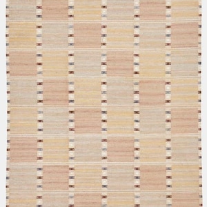 May include: A rectangular woven rug featuring a grid pattern of alternating soft peach, beige, and pale yellow squares. The grid is defined by vertical and horizontal bands with small dark blue and brown accents. The rug has a fringed edge.