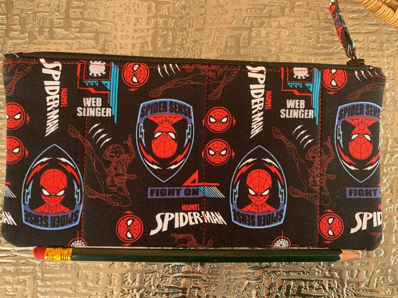 May include: Black zippered pouch with a repeating pattern of Spider-Man characters, logos, and the words "Spider-Sense", "Web Slinger", and "Fight On".