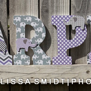 May include: Wooden letters spelling the name "HARPER" decorated with a gray and purple elephant print, chevron pattern, and polka dots.
