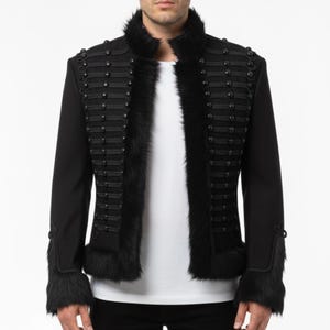 Può includere: Giacca nera in stile militare con finiture in ecopelliccia e bottoni decorativi. La giacca presenta un collo alto e dettagliate decorazioni sul davanti e sulle maniche. Un capo di abbigliamento esterno elegante e unico.