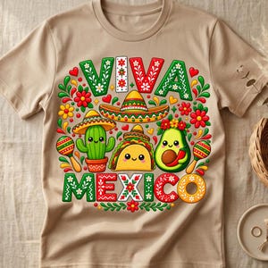 Pode incluir: Uma t-shirt bege com uma impress&atilde;o gr&aacute;fica colorida com o texto VIVA MEXICO. O design inclui um sombrero, um cato sorridente, um taco e um abacate, todos decorados com padr&otilde;es florais vermelhos, verdes e amarelos e maracas.
