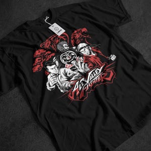 May include: Black t-shirt with a graphic design featuring characters and text from "The Karate Kid". The design incorporates red and white elements, with the words "All Valley Karate" in a stylized font. A tag reads "LARGE".