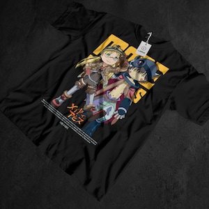 以下が含まれることがあります： 2人のキャラクターが描かれた、カラフルなアニメスタイルのイラストが特徴の黒いTシャツ。デザインには、日本語のテキストと「LARGE」の文字が入ったタグが付いた黄色の背景が含まれています。シャツは柔らかい素材で作られています。