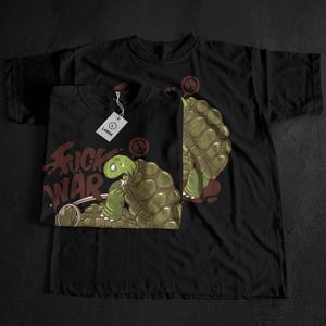 May include: Black t-shirts with a graphic of a turtle with a peace sign on its shell. The turtle is sitting on a bomb with the words "Fuck War" in brown. One shirt is folded, and the other is unfolded.