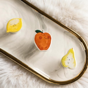 Op de afbeelding: Een witte keramische mok met een zwart handvat en de tekst "But First, Coffee" in een zwarte, handgeschreven lettertype. De mok staat op een wit oppervlak.