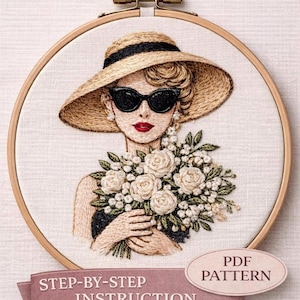 以下が含まれることがあります： 麦わら帽子とサングラスをかけた女性の刺繍肖像画。白いバラのブーケを持っています。刺繍は木製の枠にセットされています。「GLAM patterns」、「STEP-BY-STEP INSTRUCTION」、「PDF PATTERN」と書かれたテキスト。