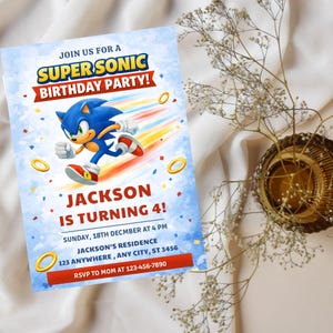 May include: A birthday party invitation featuring the character Sonic the Hedgehog. The invitation has a blue background with the text "SUPERSONIC BIRTHDAY PARTY!" and "JACKSON IS TURNING 4!". Includes party details and RSVP information.