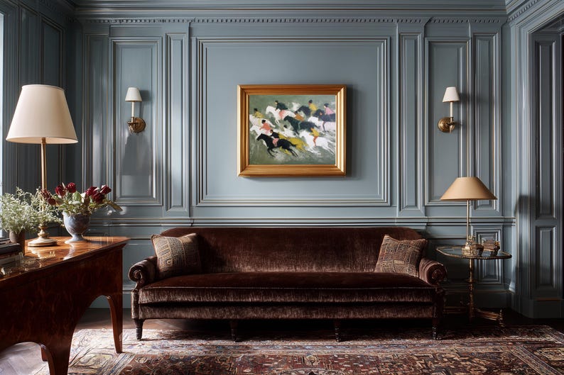 May include: A room with blue paneled walls, a brown velvet sofa, and a framed painting of horses. Two lamps with beige shades and a dark wood table are also visible. The room has a classic, elegant style.