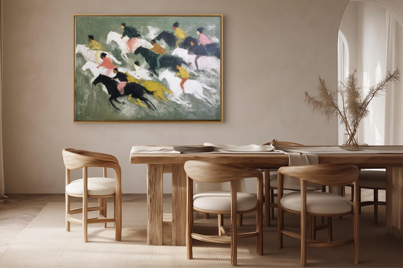 May include: An abstract painting of a horse race hangs above a wooden dining table. The artwork features riders on horses in motion, with a palette of green, black, yellow, and pink. The room includes wooden chairs and a vase of dried plants.