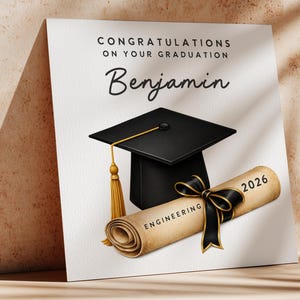 May include: A graduation card with a black mortarboard, a rolled diploma tied with a black ribbon, and the name "Benjamin". The diploma reads "Engineering" and "2026". The card has the text "Congratulations on your graduation".