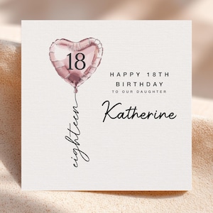 May include: A birthday card with a heart-shaped balloon that has the number 18 on it. The card says "Happy 18th Birthday to our Daughter Katherine" in black script. The word "eighteen" is written in script below the balloon.