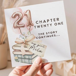 May include: A square card with the number "21" in rose gold balloon style, with the text "CHAPTER TWENTY ONE" and "THE STORY CONTINUES...". The card features a stack of books tied with a bow and the words "my girl Mila".