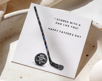 Puede incluir: Una tarjeta del Día del Padre con temática de hockey. La tarjeta presenta una ilustración de un palo y un disco de hockey. El texto de la tarjeta dice: "I SCORED WITH A DAD LIKE YOU! HAPPY FATHER'S DAY" y "BEST PUCKING DAD IN THE WORLD".