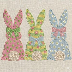 May include: Three embroidered bunny silhouettes in pink, yellow, and blue. Each bunny has a bow and a floral design. The pink bunny has green polka dots, the yellow bunny has stripes and flowers, and the blue bunny has white flowers.