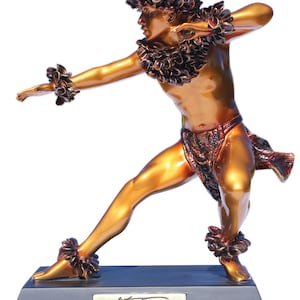 Peut inclure: Une statue en bronze d'un danseur de hula portant un collier de fleurs et une jupe en herbe. La statue est sur un socle noir avec une plaque dorée qui indique "Hula Kähiko Kane".