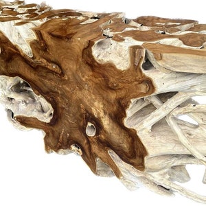 May include: A large, natural wood coffee table with a unique, organic shape. The table is made of light and dark brown wood with a natural, rustic finish.